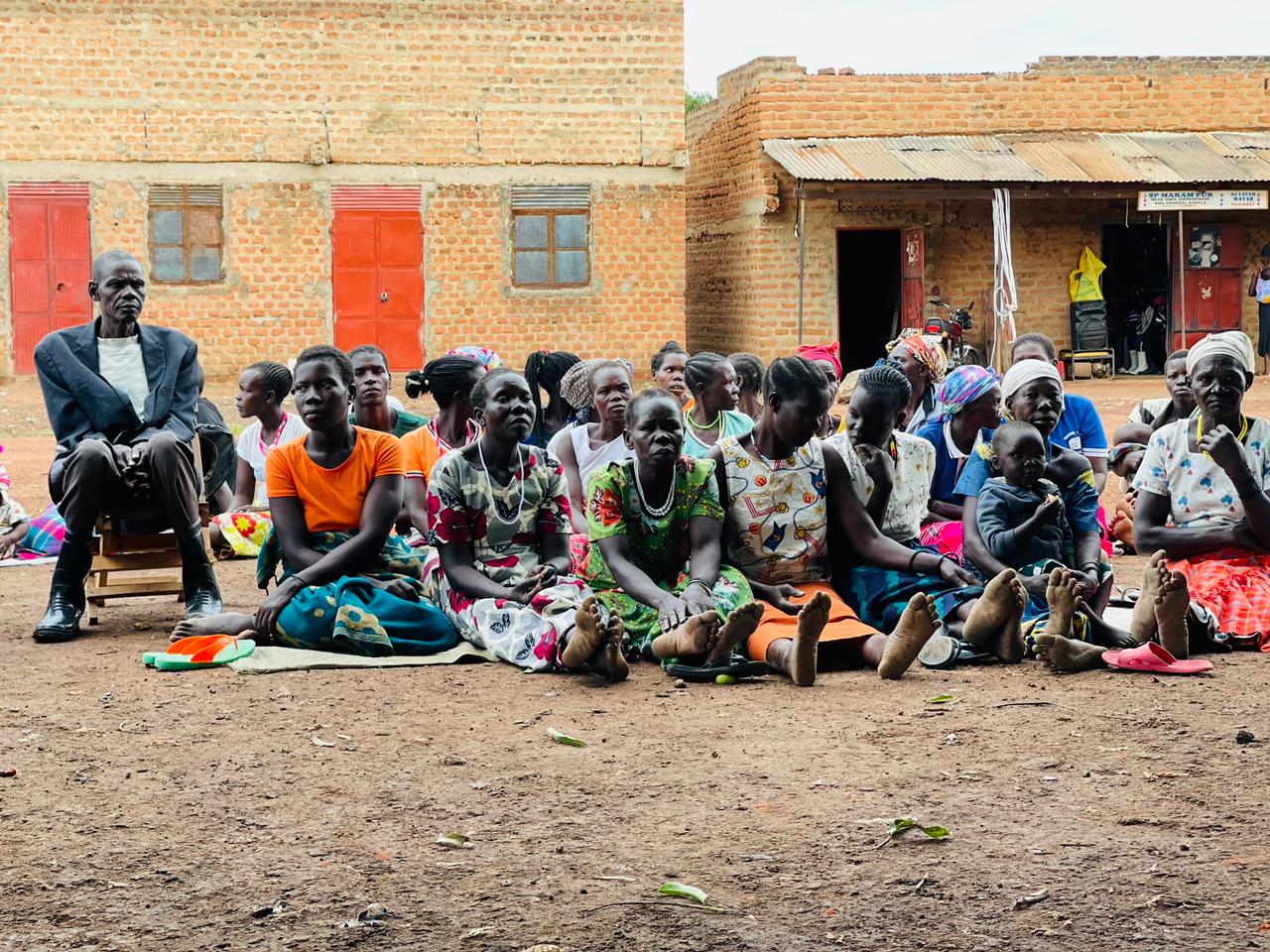 Women and community members seated during a local stakeholder engagement